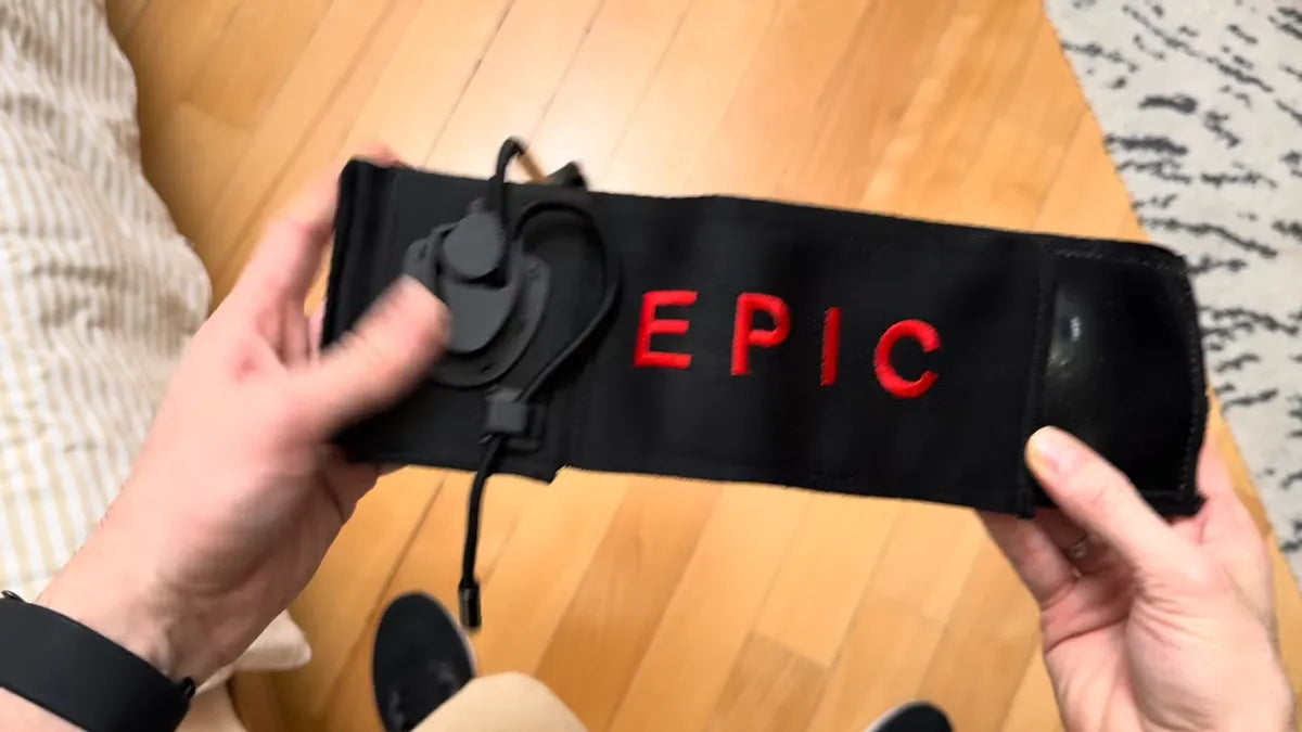 Hands holding the Epic All Day Stretcher band with its cord holder and elastic cord